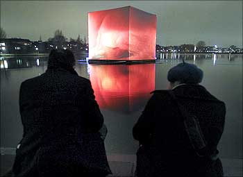 People watch an illuminated so-called CO2 cube pictured in the water of St Jorgens Lake, Copemhagen.