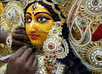 A sculptor applies the finishing touches to an idol of the Hindu goddess Durga.