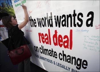 Image:  A woman signs a placard asking for a deal in the climate meeting. Photograph: Daniel Munoz/Reuters