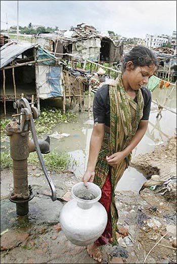 A woman carry drinking water from a village pump.