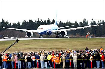 Boeing employees crowd the tarmac as the company's 787 Dreamliner taxies down the runway.