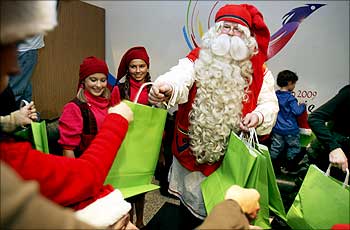 A man dressed as Santa Claus distributes gift upon his arrival, from his village in the artic circle of Finnish Lapland, at Beirut international airport.