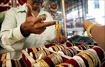 A shopkeeper shows gold bangles to a prospective buyer at a jewellery shop in Mumbai.