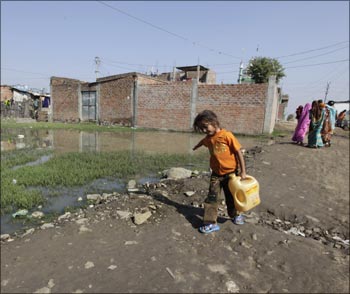 A girl carries water in a slum area next to the Union Carbide Corp pesticide plant in Bhopal.