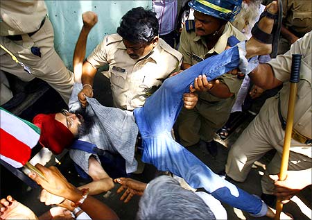 Police forcibly remove a human rights activist from the venue of a demonstration against SEZs near Mumbai.