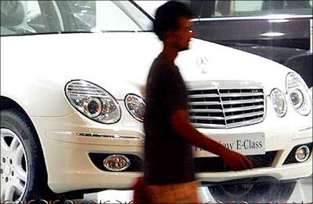 A man walks past a car displayed at a Mercedes-Benz showroom in Mumbai.