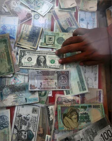 A currency dealer displays various currencies at his roadside money changer stall in Karachi.