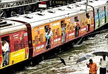 A train moves through a flooded track after heavy rains in Mumbai.