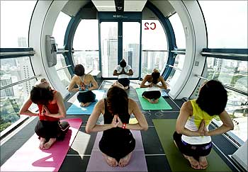 People take part in a yoga class on a capsule of the Singapore Flyer observation wheel.