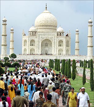 Tourists walk in front of the historic Taj Mahal in Agra.