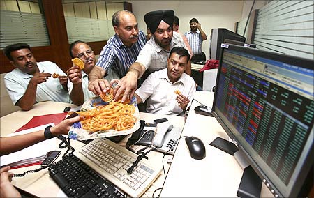 Traders eat sweets at a brokerage in Chandigarh.