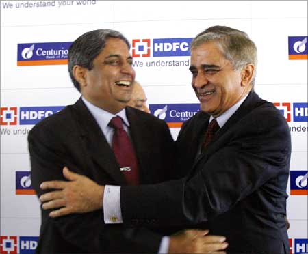 Aditya Puri (L), managing director of HDFC Bank, embrace Rana Talwar (R), chairman of Centurion Bank of Punjab.