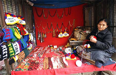 A Buddhist woman wraps wool inside her shop selling ornaments and caps in Mcleodgunj.
