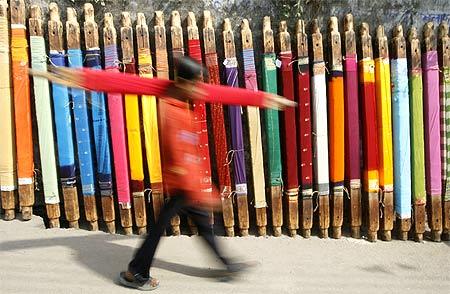 A labourer carries a roll of cloth at a roadside dye factory in Siliguri.