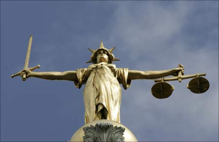 The Statue of Justice, depicted as a woman with a sword in one hand and scale in her other, is seen on top of the London Central Criminal Court, the Old Bailey in London.