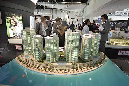 Visitors look at a model of a new real estate project at the Cityscape Abu Dhabi Exhibition.