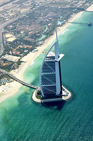 An aerial image with the Burj Al Arab in the foreground, shows the approaching 'red tide', on the shores of Dubai.