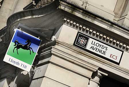 A Lloyds TSB branch sign is seen next to a street sign in The City of London.