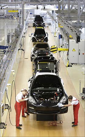 Workers inspect a Panamera car.