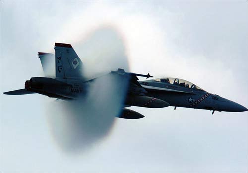 Water vapour builds up around a US Navy F/A-18F Super Hornet as it breaks the sound barrier during a fly-by. The Super Hornet engines are powered by GE.