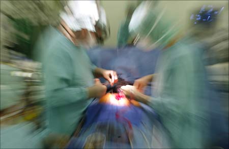 A zoomed picture shows two surgeons performing an operation to implant an artificial heart valve.
