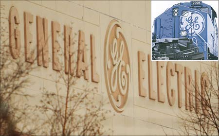General Electric logo visible on a facility in Lynn, Massachusetts. (Inset) A GE-powered locomotive.