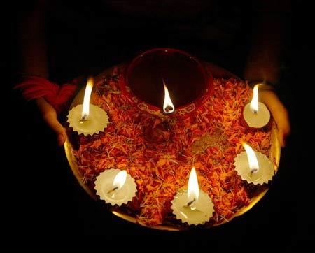 India has shining potential: A girl holds lighted lamps during Diwali celebrations in Siliguri.