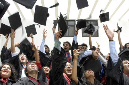 Universities: Students of a graduating class throw their caps in the air.