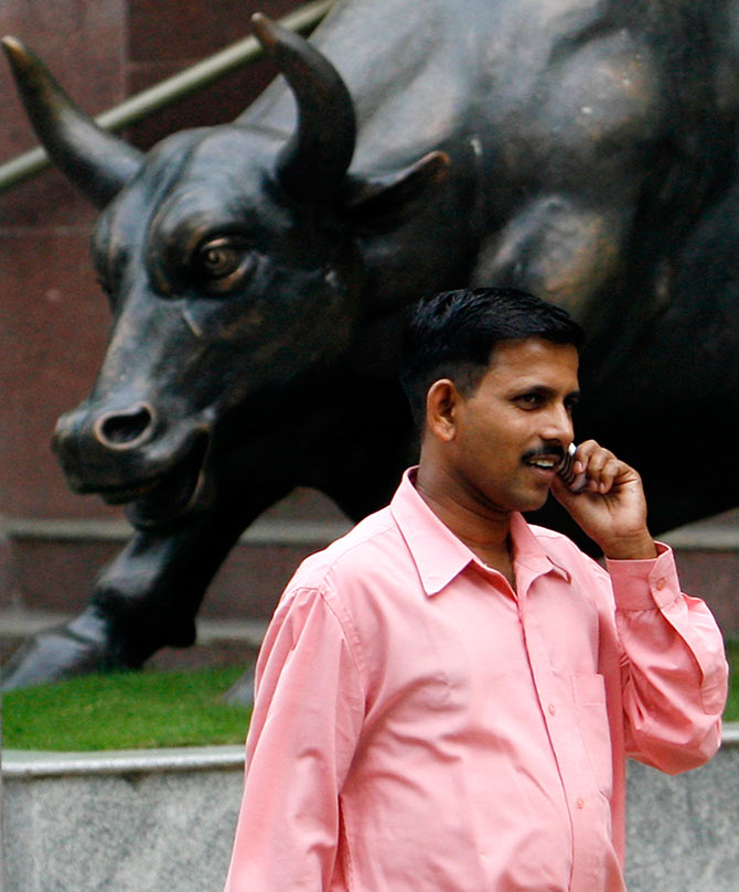 A man passes by the BSE Bull at the BSE building.