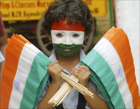 A school girl with her face painted in the colours of the Indian national flag holds flags during Independence Day celebrations at a school in Patna.