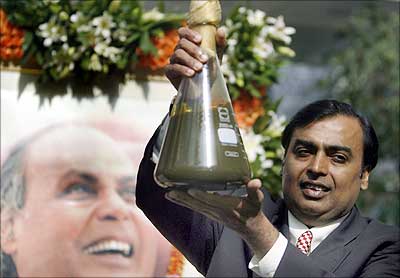 Mukesh Ambani holds a jar containing the first crude oil produced from their company's KG-D6 block.