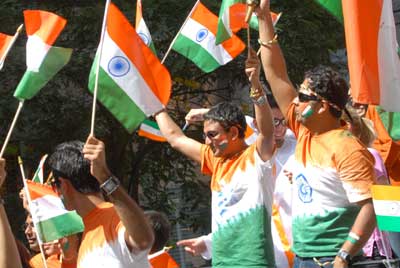 Indian students waving the Indian flag at a parade in New York.