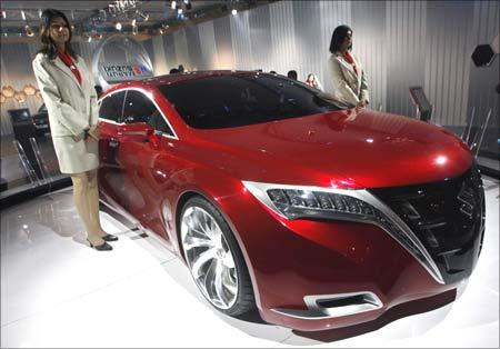 Models stand next to Maruti-Suzuki's Kizashi concept car.