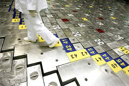 A specialist walks on the head of a nuclear reactor.