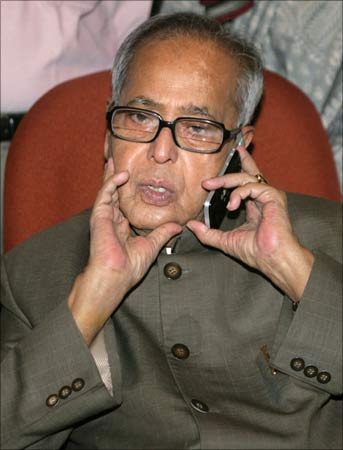Finance Minister Pranab Mukherjee speaks on a mobile phone on his first day in the office in New Delhi.