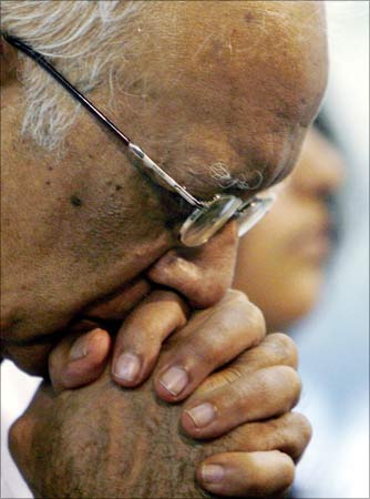 An old man prays during a service for the victims of the attacks by armed terrorists in Mumbai.