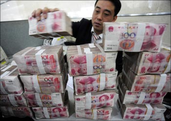 An employee counts Renminbi banknotes at a Bank of China branch in Hefei, Anhui province.