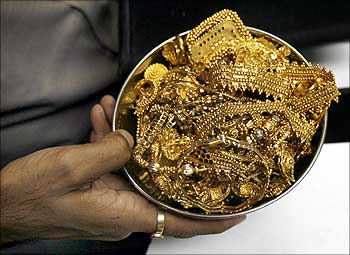 A trader holds gold jewellery at a shop in Mumbai.
