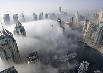 Fog rolls by early in the morning, near the Dubai Marina construction and residential zone.