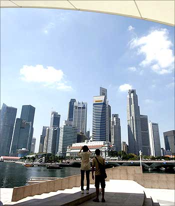 A tourist takes a photo of Singapore's financial district skyline.