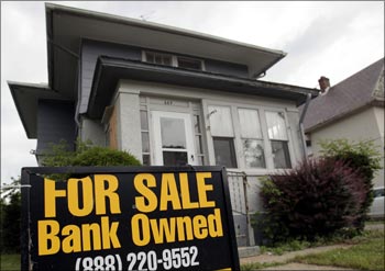 A 'For Sale-Bank Owned' sign sits in front of a home in Pontiac, Michigan.