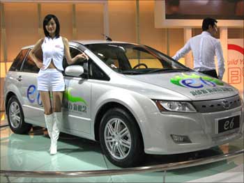 Models pose beside BYD's electric car.