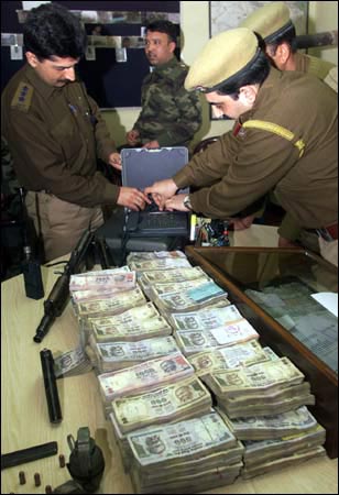 Indian police officers examine seized currency notes in Srinagar.
