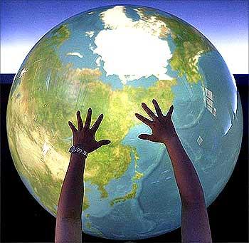 A visitor places her hands on a Tangible Earth, a digital globe which real time global metrological data is fed through the Internet from about 300 places in the world in Japan.