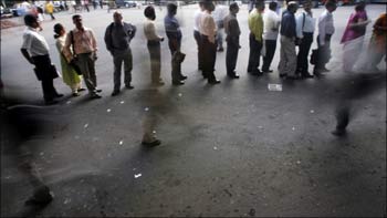 Office-goers stand in a queue in Mumbai.