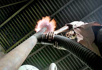 An Indian worker adjust gas pipeline inside a biomass gasifier power plant in Gosaba.