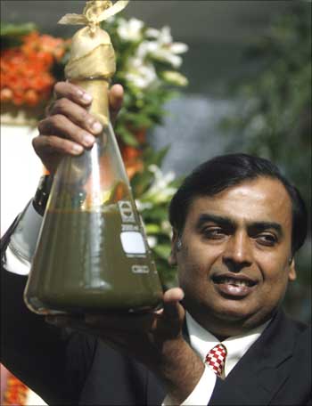Mukesh Ambani, chairman of Reliance Industries, holds a jar containing the first crude oil produced from their company's KG-D6 block in the country's east coast.