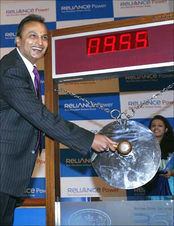Anil Ambani, chairman of Anil Dhirubai Ambani group, strikes a gong as other officials watch during the listing ceremony of Reliance Power at the Bombay Stock Exchange in Mumbai February 11, 2008.