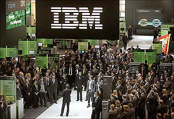 Employees follow a speech at the booth of IBM at CeBIT computer fair in Hanover.