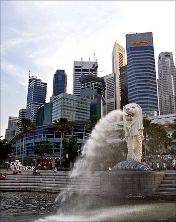 People sit on the steps near the Merlion in Singapore's financial district.